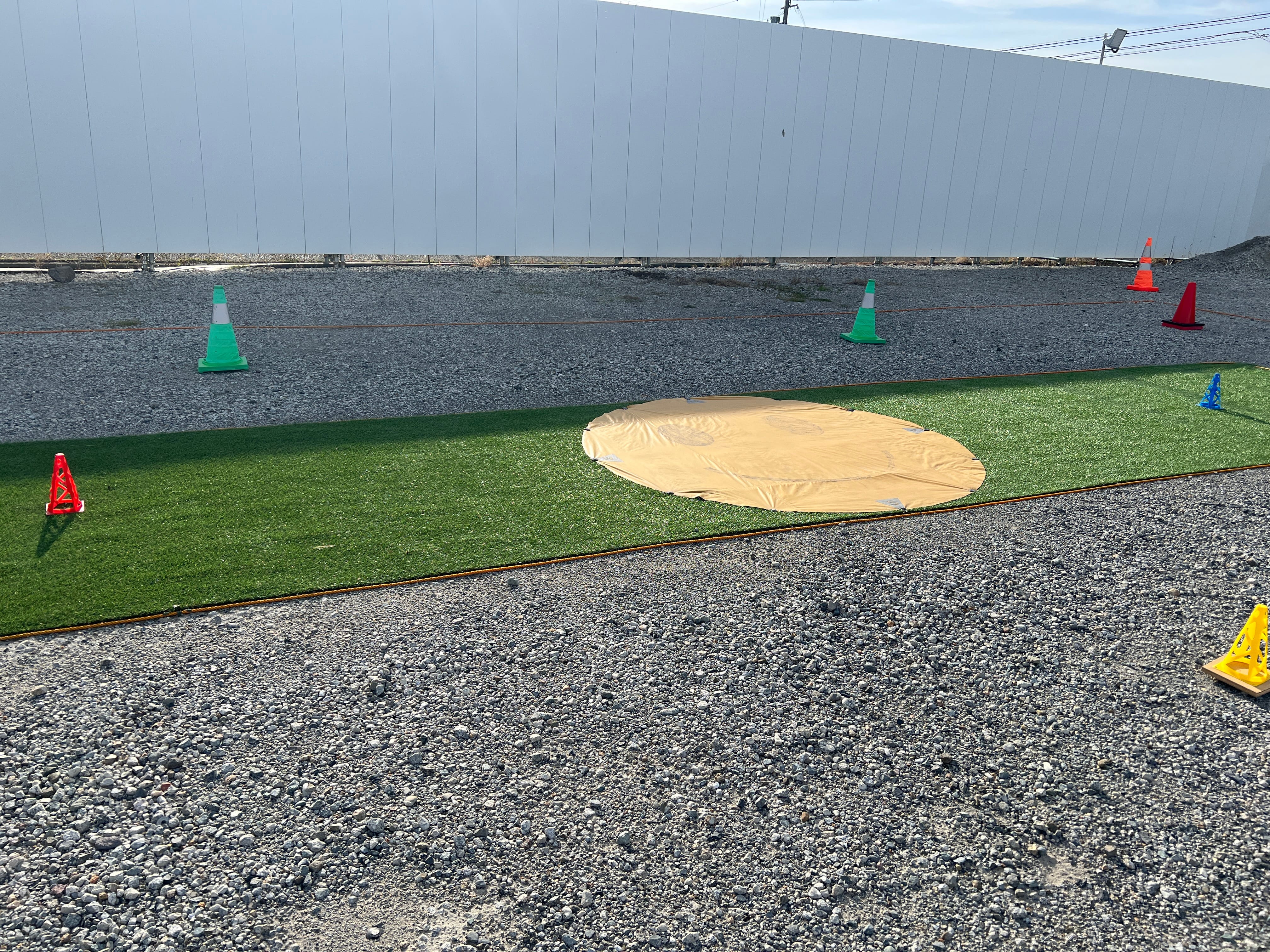 芝生フィールドでホバリング練習を行う受講生と講師