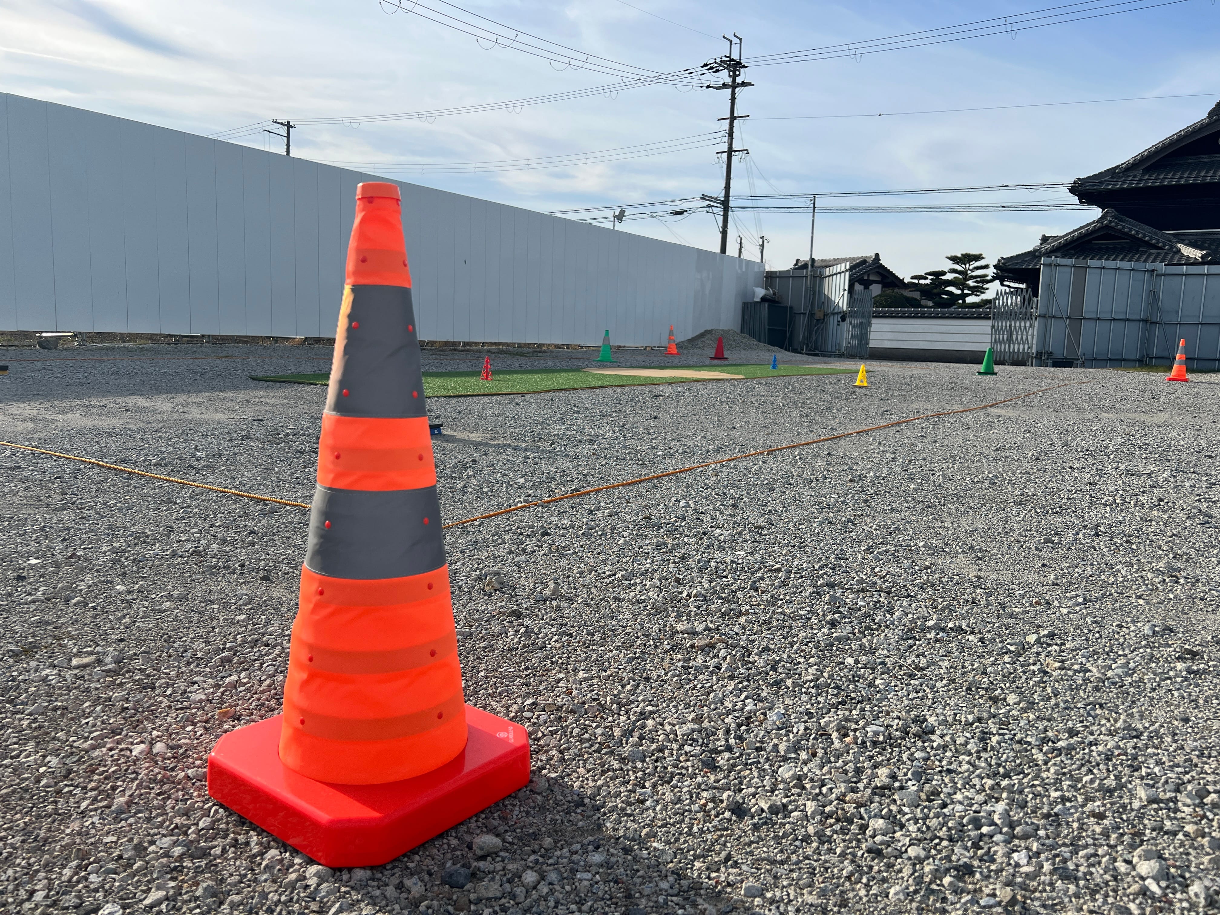 滑走路の屋外フィールドで講習を受ける受講生とインストラクター